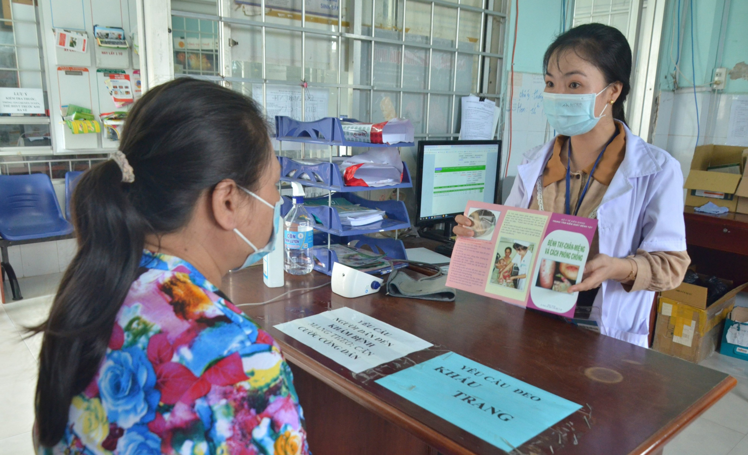 Nhân viên Trạm Y tế phường Vĩnh Quang, thành phố Rạch Giá lồng ghép tuyên truyền phòng, chống bệnh tay chân miệng cho người dân khi đến trạm khám bệnh. Ảnh: Mi Ni