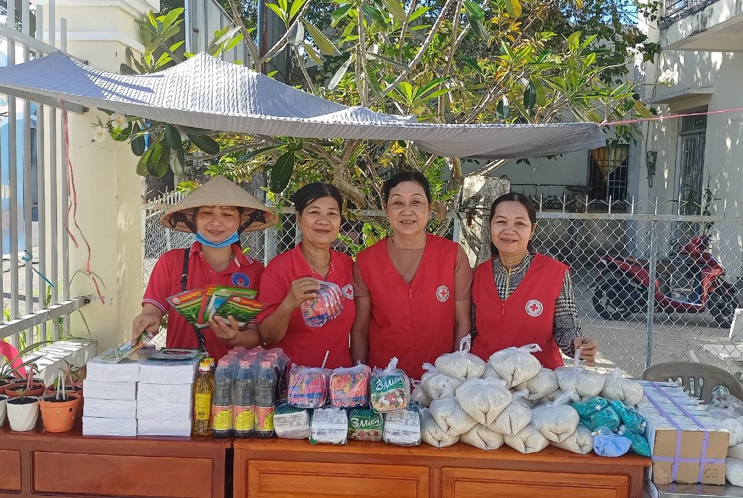 Cô Nguyễn Hồng Xuân (thứ 3, từ trái qua) phát nhu yếu phẩm cho hộ nghèo, hộ cận nghèo trên địa bàn. Ảnh: Thanh Nhàn