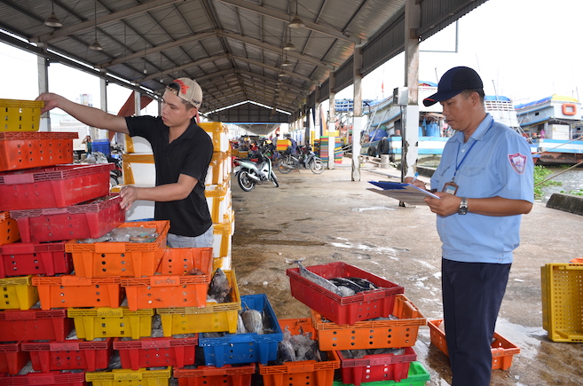 Nhân viên Ban quản lý Cảng cá tỉnh Kiên Giang kiểm soát sản lượng thủy sản cập cảng cá Tắc Cậu, huyện Châu Thành. Ảnh: Thùy Trang